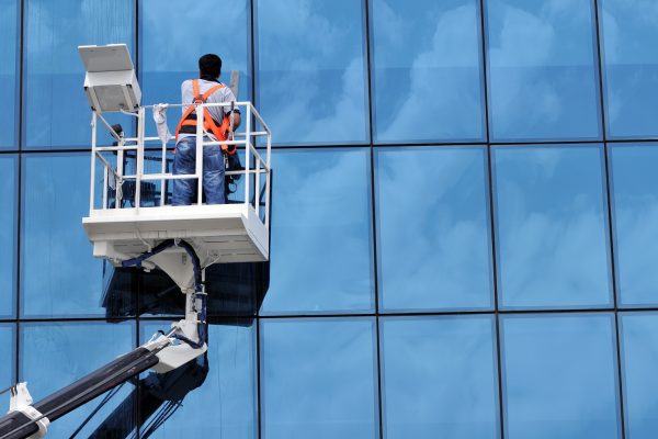 Window cleaner working on a glass facade in a gondola